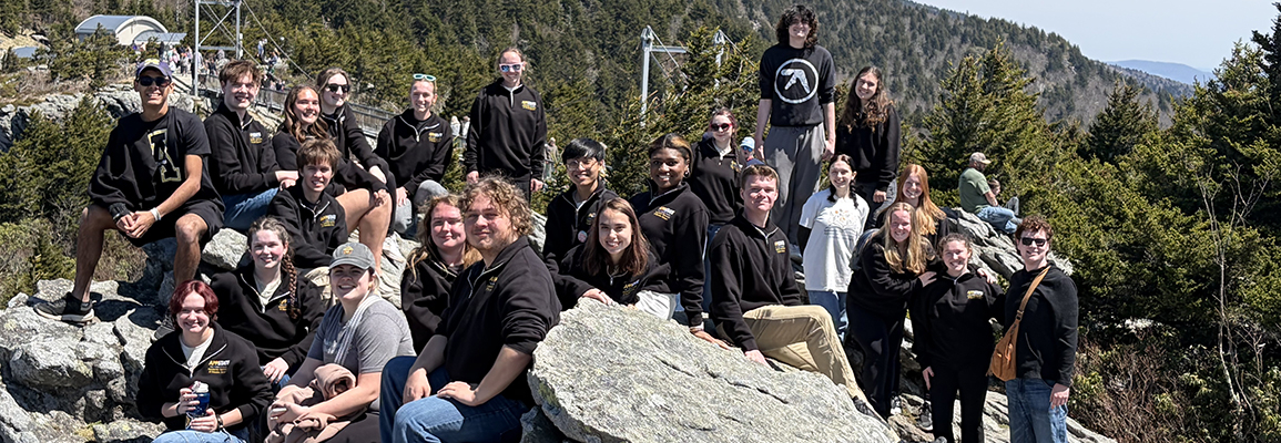 Group of students pose in front of Grandfather Mountain. 